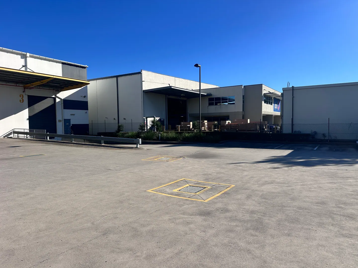 A commercial site with loading areas and maintained planting along the buildings