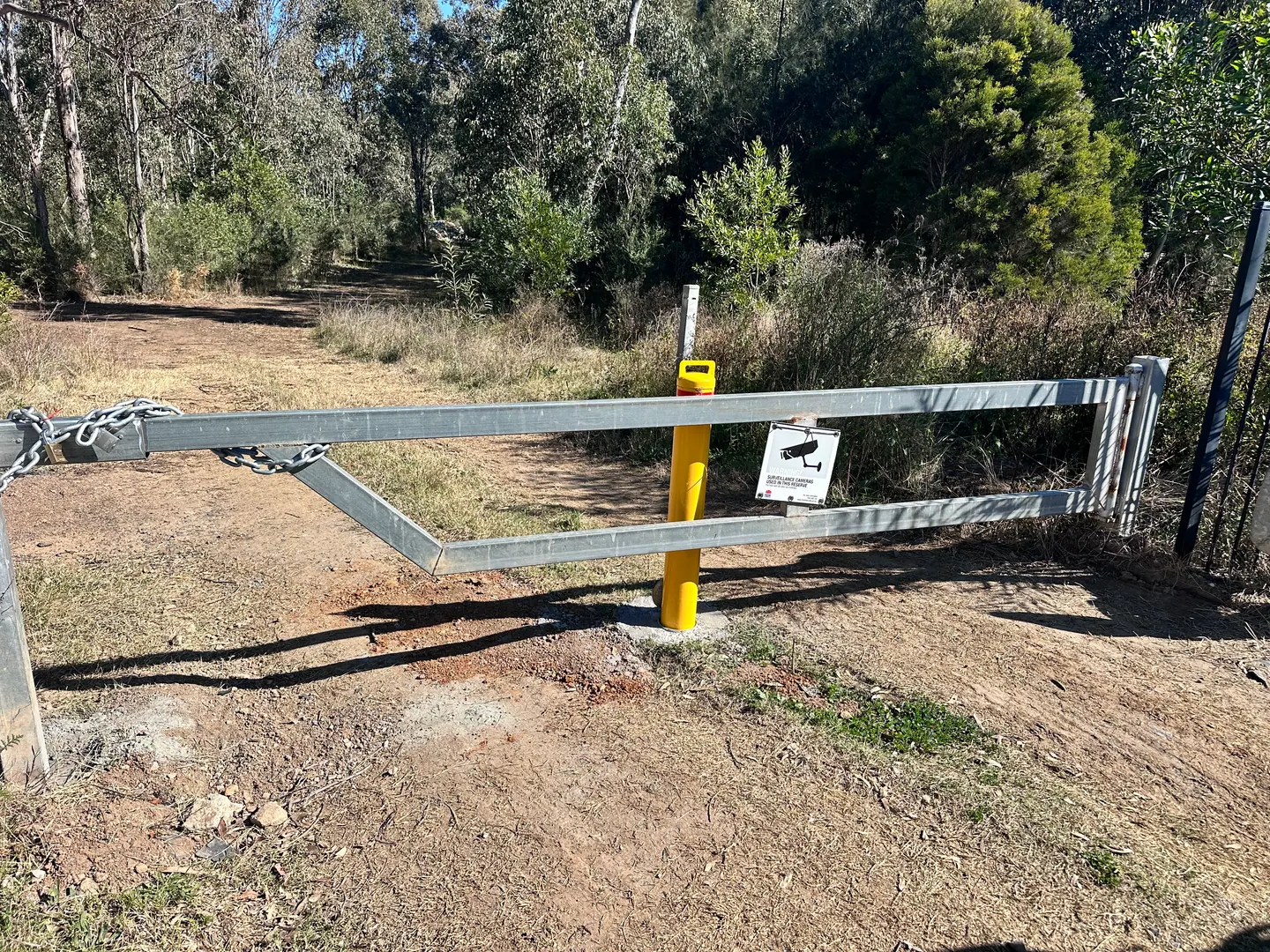 A gate and secured yellow bollard at a Crown Land access point