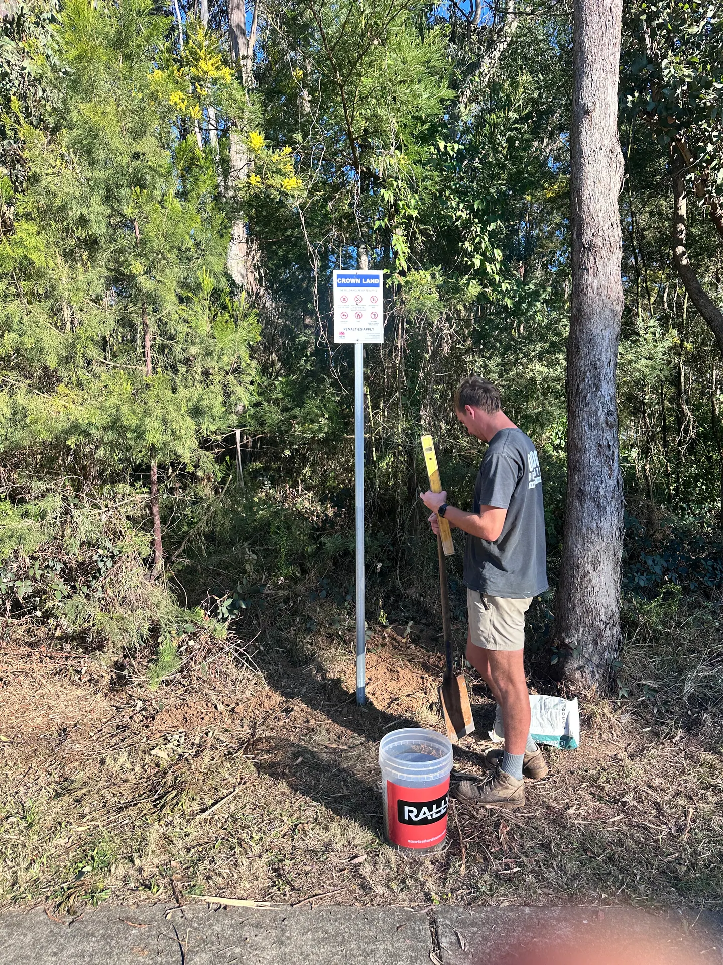 A team member checking a Crown Land signpost with a spirit level